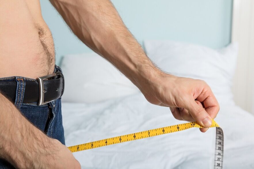 Млад мъж измерва дължината на пениса си